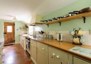 a large kitchen with a wooden counter top at Locks Lane Cottage in Geldeston