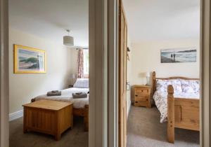 a bedroom with a bed and a table in it at Locks Lane Cottage in Geldeston