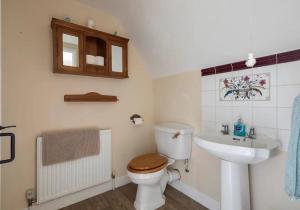 a bathroom with a toilet and a sink at Locks Lane Cottage in Geldeston