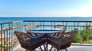 a table and chairs on a balcony overlooking the ocean at Beachfront Havana in Sveti Vlas