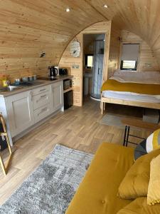 a room with a bed and a kitchen in a cabin at Lochside Lodge Pod in Lairg