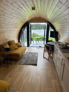 a living room with a couch and a table at Lochside Lodge Pod in Lairg