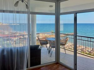 a room with a view of the ocean from a balcony at Beachfront Havana in Sveti Vlas