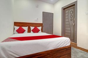 1 dormitorio con 1 cama grande con almohadas rojas en OYO Flagship Hotel Lavish Stay en Hyderabad