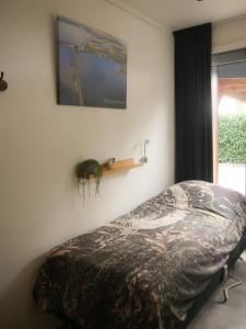 1 dormitorio con 1 cama y TV en la pared en BenB Weerribben Wieden, en Wanneperveen