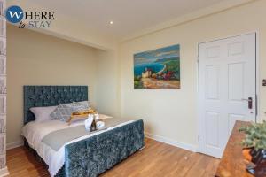 1 dormitorio con 1 cama y una pintura en la pared en Stylish 3 Bedroom Apartment, Edinburgh, en Edimburgo