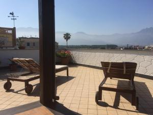 two chairs sitting on a patio with a view of the mountains at Apartment Pompei Wellness in Pompei