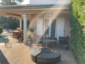 a patio with a table and chairs on a deck at Suite parentale avec salle de bains et toilettes privées in Genas