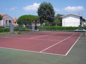 een tennisbaan met een net erop bij Precious villa with private garden and barbecue in Porto Santa Margherita di Caorle