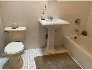 een badkamer met een toilet, een wastafel en een bad bij Locals Fort Greene Apartments in Brooklyn