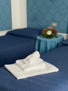 un paio di asciugamani posti sopra un letto di Hotel Michelangelo a Rezzato