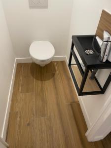 a bathroom with a toilet and a black table at Suite parentale avec salle de bains et toilettes privées in Genas