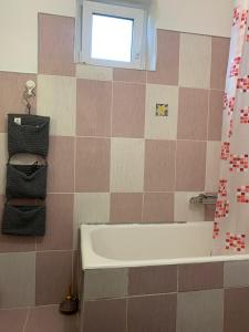La salle de bains est pourvue d'une baignoire et d'une fenêtre. dans l'établissement Andreea Residence, à Ghimbav