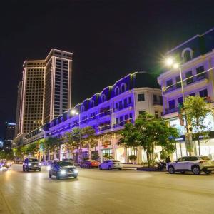 a city street with cars parked in front of buildings at night at Private homestay sea view in Halong center in Ha Long