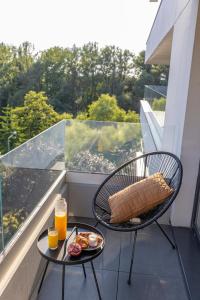 奧斯威辛的住宿－River Side Residence 3/19，阳台配有餐桌,提供早餐食品和橙汁