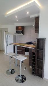 a kitchen with a counter and two stools in it at Casa 3 ambientes in Balneario Mar Chiquita