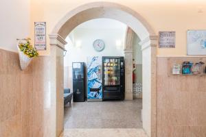 ein Torbogen, der in ein Geschäft mit einem Verkaufsautomaten führt in der Unterkunft Norte Guest House in Lissabon