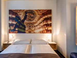 B&B Hotel Bayreuth في بايروث: غرفة نوم فيها لوحة كبيرة فوق سرير