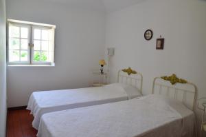 Cette chambre blanche dispose de 2 lits et d'une fenêtre. dans l'établissement Casal do Outeiro by LovelyStay, à Marco de Canavezes