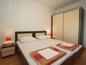 a bedroom with a large bed with white sheets at Apartments Novalja in Novalja