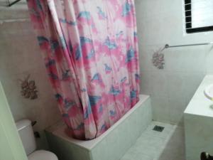 a bathroom with a shower curtain and a toilet at Bay Marina Cox's Bazar in Kelātali