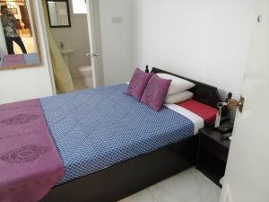 1 dormitorio con 1 cama con almohadas moradas y blancas en Bay Marina Cox's Bazar, en Kelātali