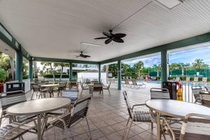 a patio with tables and chairs and a pool at Our House at the Beach W-Tower 5th Fl in Siesta Key