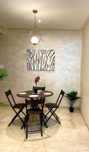 a dining room table with chairs and a potted plant at Stunning luxury apartment in the heart ofmarrakech in Marrakech