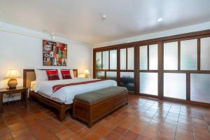 una camera da letto con un grande letto con cuscini rossi di Beachside Apt. Short Walk to Nai Harn Beach - 2BR a Nai Harn Beach