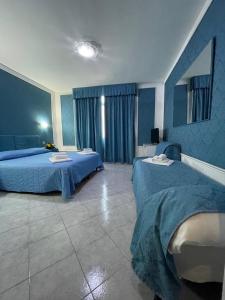 um quarto com 2 camas e paredes azuis em Hotel Michelangelo em Rezzato