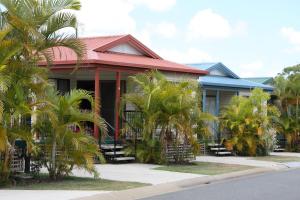 dom z palmami przed nim w obiekcie Brisbane Gateway Resort w mieście Rochedale