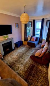 ein Wohnzimmer mit einem Sofa und einem Kamin in der Unterkunft Bournemouth Beach Boutique with Hot Tub - sleeps up to 20 in Bournemouth