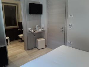 ブレンゾーネにあるHotel Danieli La Castellana lago di Gardaのベッドと電話が備わるホテルルームです。