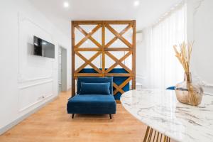 a dining room with a table and a blue chair at Via Augusta 129 in Lisbon