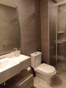 La salle de bains est pourvue de toilettes, d'un lavabo et d'une douche. dans l'établissement 2 Dormitorios en Villa Morra, à Asuncion