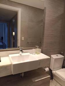 La salle de bains est pourvue d'un lavabo, de toilettes et d'un miroir. dans l'établissement 2 Dormitorios en Villa Morra, à Asuncion