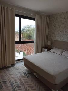 - une chambre avec un lit et une grande fenêtre dans l'établissement 2 Dormitorios en Villa Morra, à Asuncion