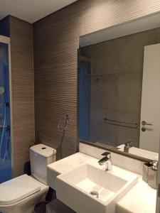 La salle de bains est pourvue d'un lavabo, de toilettes et d'un miroir. dans l'établissement 2 Dormitorios en Villa Morra, à Asuncion
