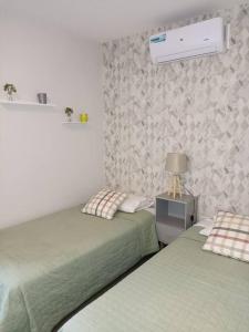 a bedroom with two beds and a lamp on a table at 2 Dormitorios en Villa Morra in Asunción