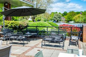 a patio with tables and chairs and an umbrella at Crowne Plaza Reading in Reading
