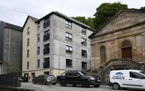 a white van parked in front of a building at Dalwhinnie Apartment in Oban