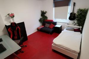 ein Schlafzimmer mit einem Bett und einem Schreibtisch mit einer Gitarre in der Unterkunft Private Apartment in Hannover