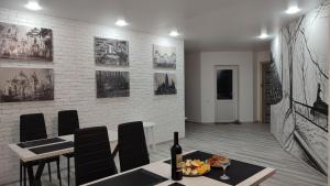 a dining room with a table and chairs and a brick wall at Koteg LEMBERG in Slavske