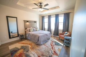 ein Schlafzimmer mit einem Bett, einem Ventilator und einem Stuhl in der Unterkunft Hollywood Hangout - New West Properties in Kanab