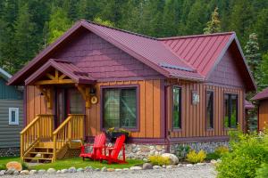 a small cabin with red chairs in front of it at Bear Hill Lodge in Jasper