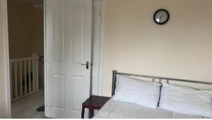 a bedroom with a bed with a clock on the wall at Salimi in Bridgend