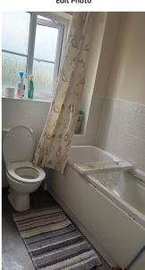 baño con aseo, bañera y ventana en Salimi, en Bridgend 1 foto más