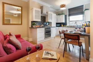 a living room with a red couch and a kitchen at Albert Road Apartments Flat 2 in Colne