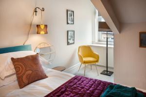ein Schlafzimmer mit einem Bett und einem gelben Stuhl in der Unterkunft Albert Road Apartments Flat 2 in Colne