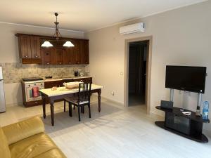 eine Küche und ein Wohnzimmer mit einem Tisch und einem TV in der Unterkunft Casa dolce casa in Trecastagni